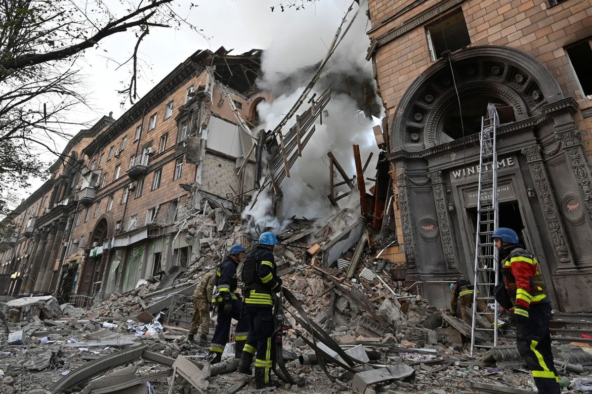 Rescue workers assess the destruction of a collapsed building, with debris scattered and smoke rising from the scene.