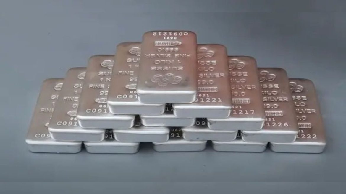The image shows a stack of silver bars, each engraved with "Suisse 1 Kilo Fine Silver 999.0." The bars are arranged in a pyramid-like formation, highlighting their clean, shiny surfaces and detailed engravings.