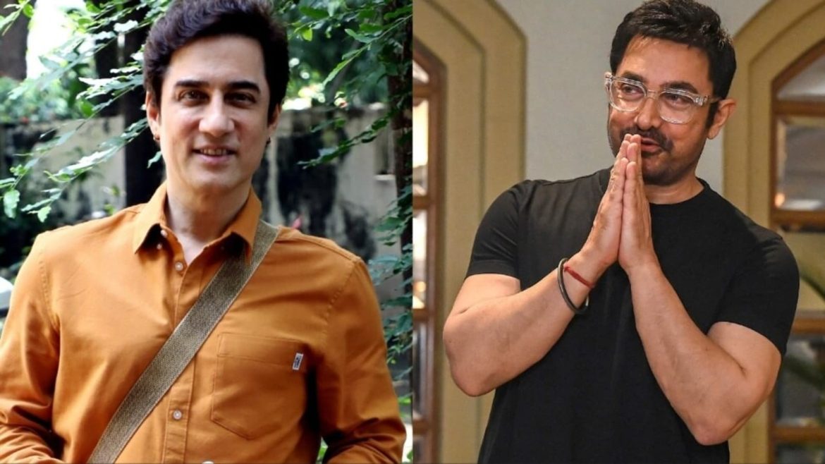Two men are shown side by side. One wears an orange button-up shirt with a strap, while the other is dressed in a black t-shirt, hands in a prayer pose.