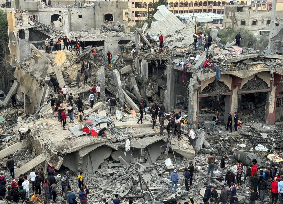 A crowded disaster site with people sifting through rubble and debris of collapsed buildings, highlighting the aftermath of destruction.