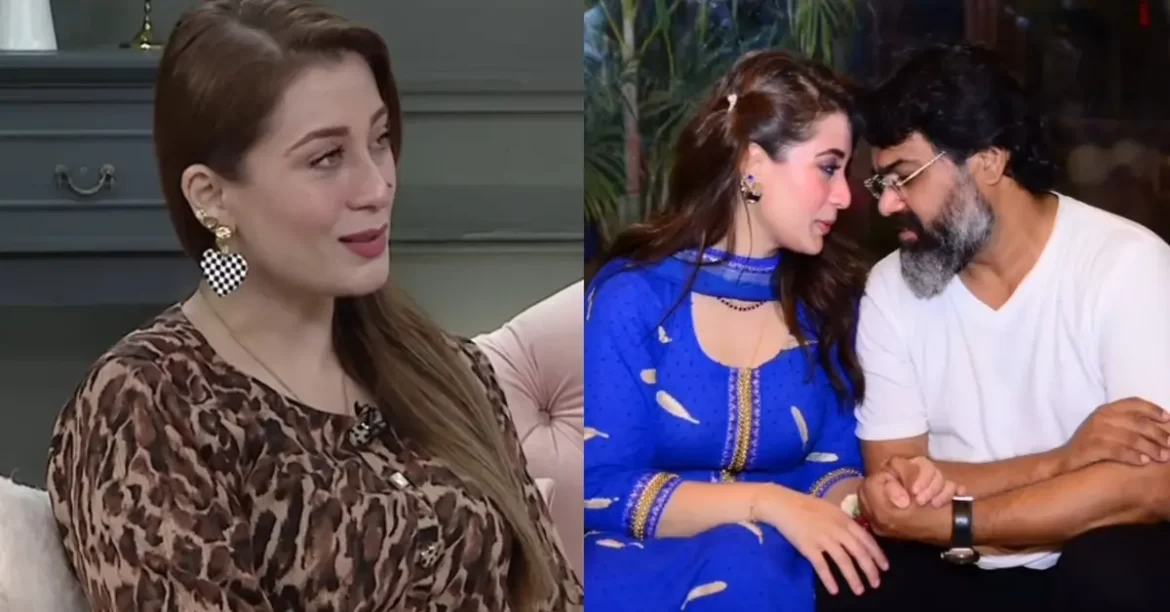 Two women in stylish clothing, one in a leopard print top and the other in a blue traditional outfit, share an intimate moment.