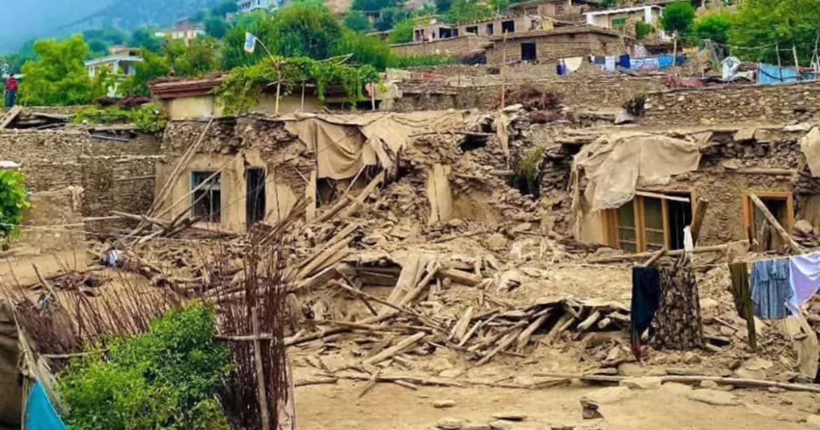 A devastated village with crumbled stone houses, exposed wooden beams, and torn fabric, amidst lush greenery and laundry hanging to dry.
