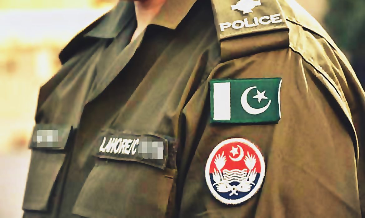A close-up of a police officer's uniform featuring the Pakistan flag, a Lahore badge, and the police emblem on the shoulder.