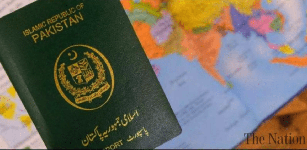A Pakistani passport is held in front of a world map, symbolizing travel and international identity.