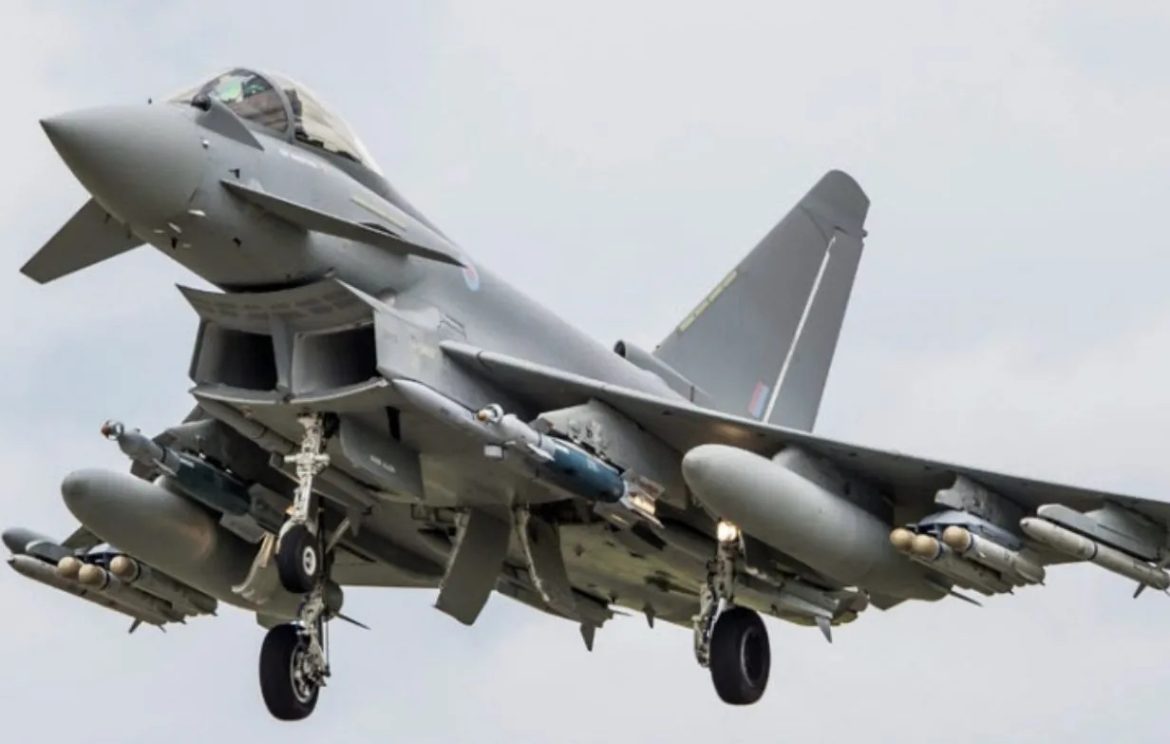 A Eurofighter Typhoon jet descends for landing, showcasing its sleek design and armed with various munitions underneath its wings.