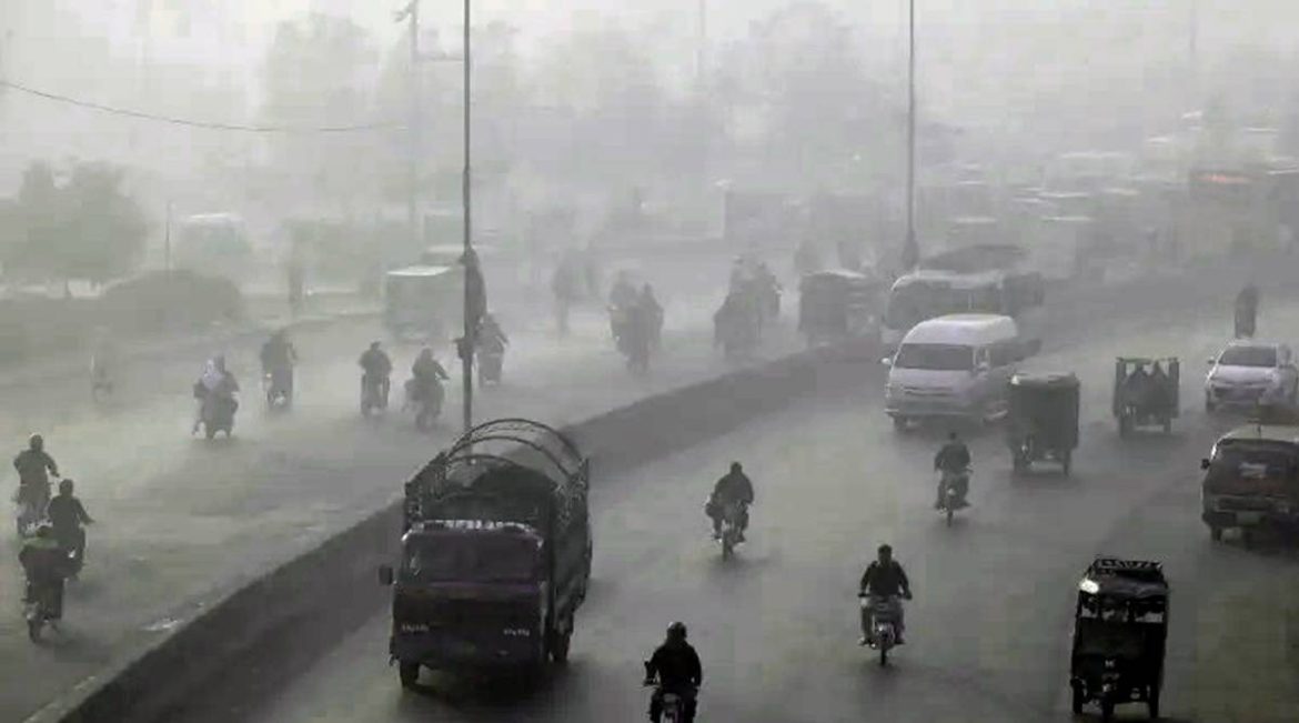 A foggy street scene with various vehicles and cyclists navigating through low visibility and haze.