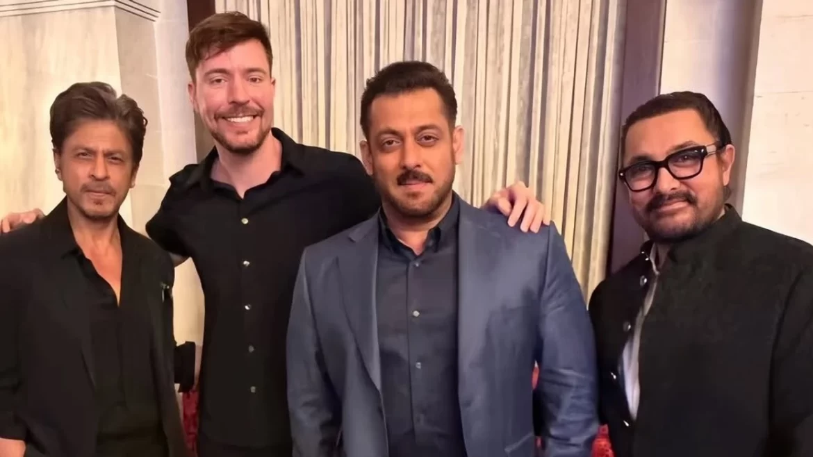 Four men pose together, dressed in stylish black attire, against a backdrop of elegant curtains, exuding camaraderie and sophistication.