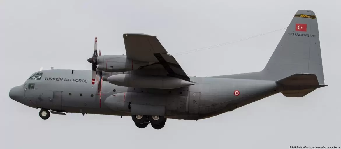 A Turkish Air Force C-130 transport aircraft in flight, displaying the national flag and insignia on its tail.
