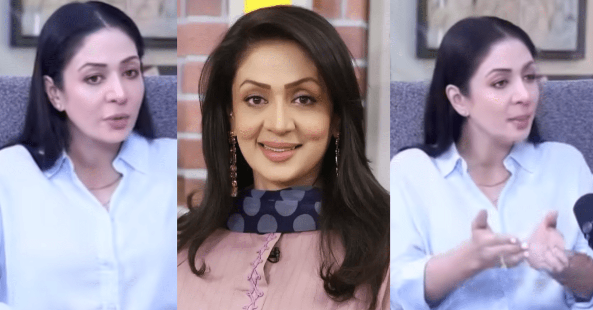 A woman in a light blue shirt gestures while speaking, showcasing a dynamic discussion environment with brick wall backdrop.