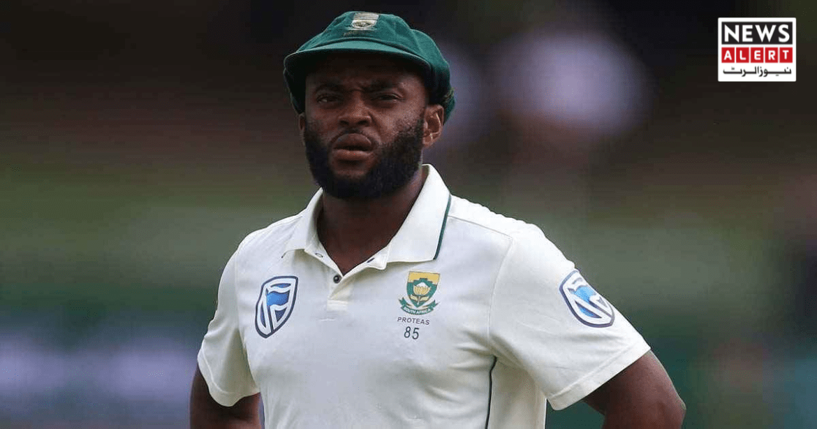 A South African cricketer stands on the field, wearing a white jersey with a green cap, focused on the game ahead.