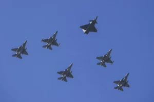 A formation of six fighter jets soaring through a clear blue sky, showcasing military aviation prowess.