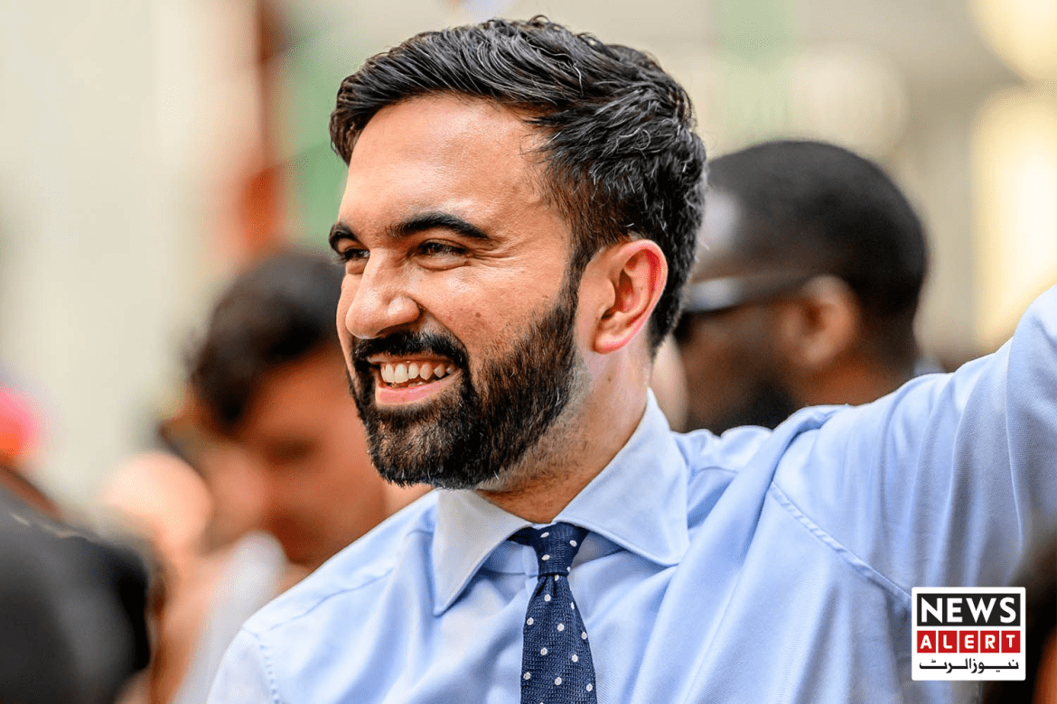 A man in a blue shirt and polka dot tie raises his arm, surrounded by a crowd, with a news alert banner in the corner.