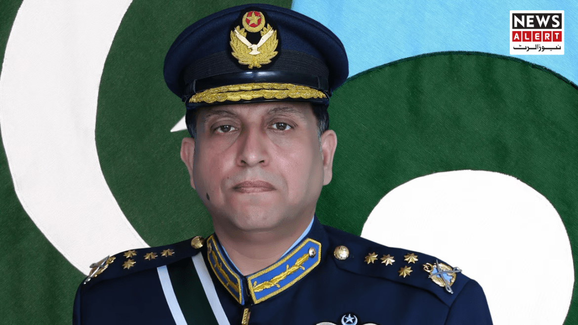 A military officer in a formal uniform stands against a backdrop featuring the green and white colors of the Pakistani flag.