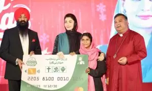 A group holds a large card displaying logos, with a festive background and celebratory atmosphere.