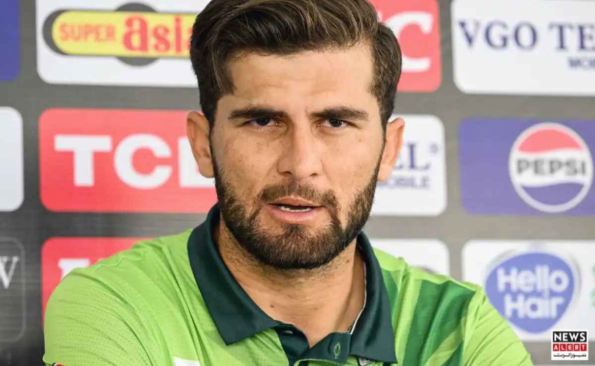 A person in a green jersey is sitting at a press conference, with branded backdrop and logos visible behind them.